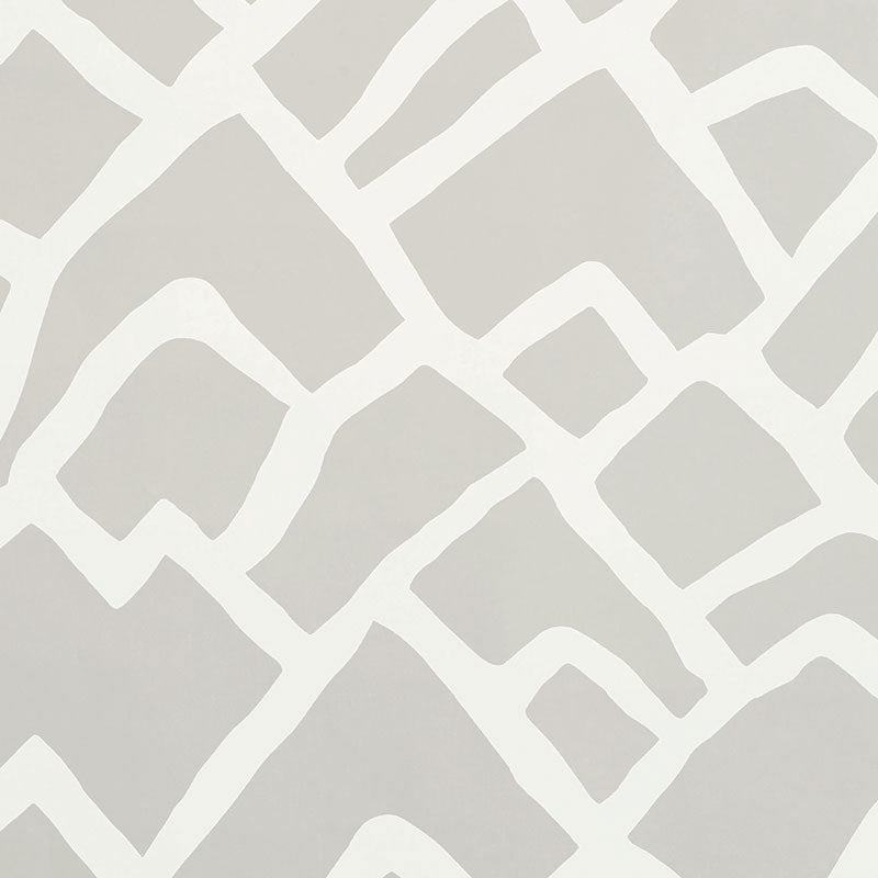 Zimba Fog by Schumacher - abstract hand-printed geometric wallpaper in soft grey and white, shown in a modern living room interior.