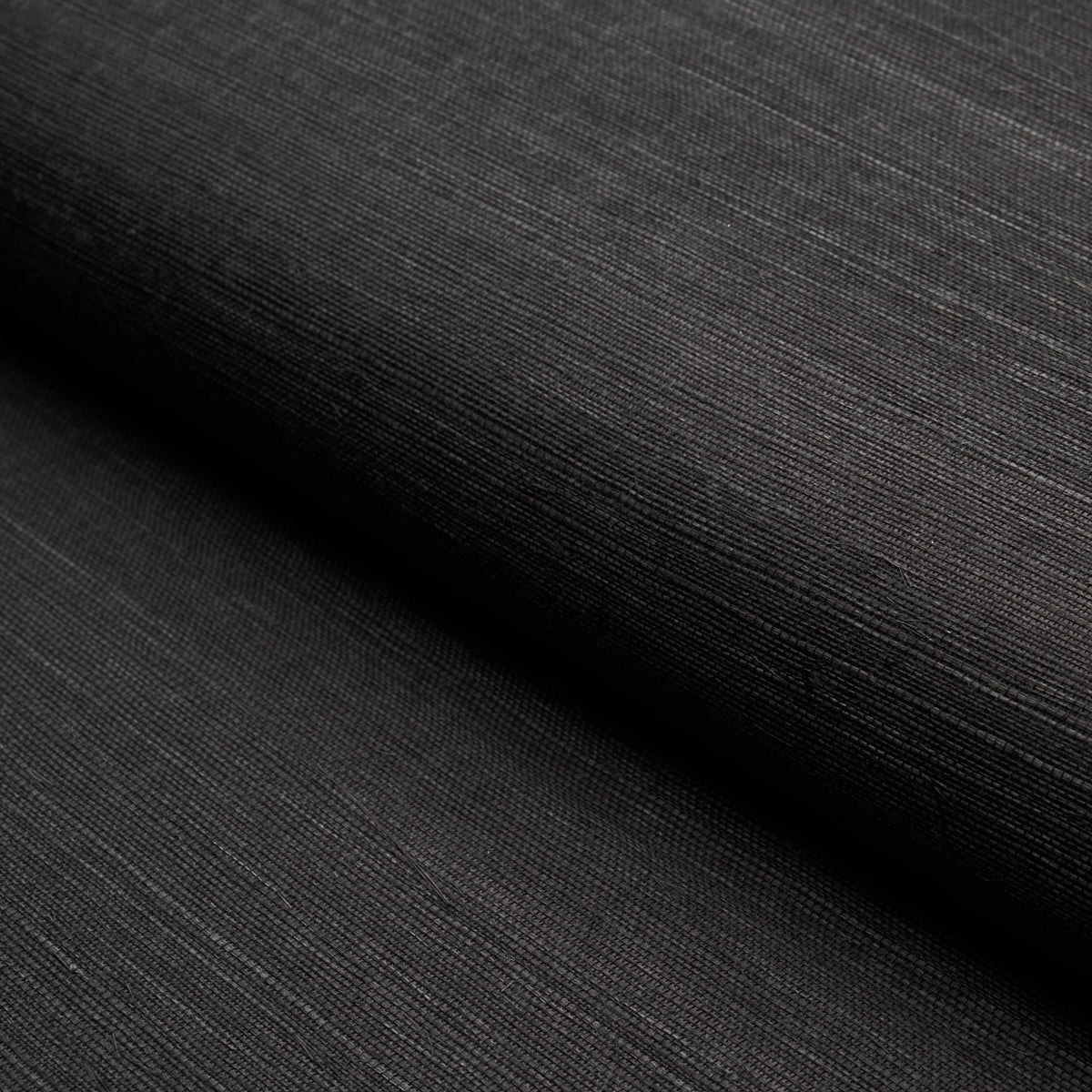 HARUKI SISAL Jet black textured sisal wallpaper by Schumacher, shown in a close-up and in a stack of colorways.