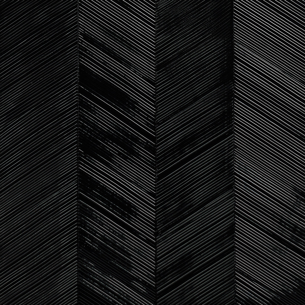 Chevron Texture Onyx wallcovering with raised diagonal stripes in a wide herringbone pattern and metallic luster by Schumacher.