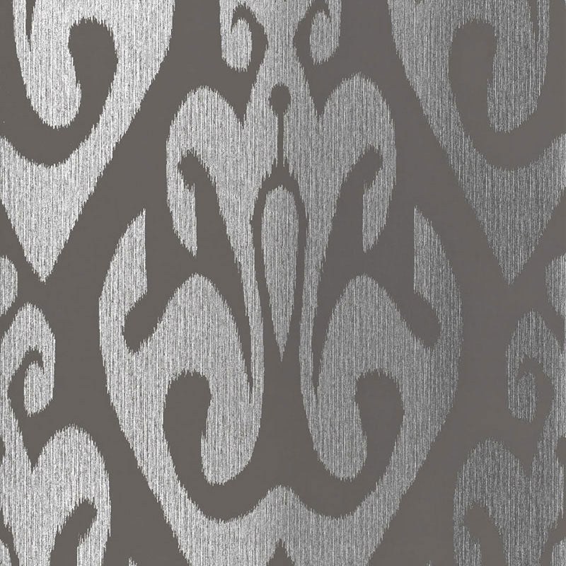 TOKAT wallpaper in graphite, a bold ikat-inspired pattern from Schumacher's Byzantium collection, shown in metallic silver and dark gray.