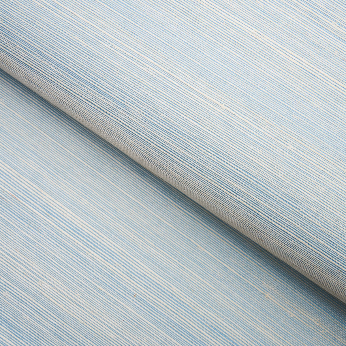 Haiku Sisal Cerulean wallpaper by Schumacher shown in a close-up and installed in a dining room setting.