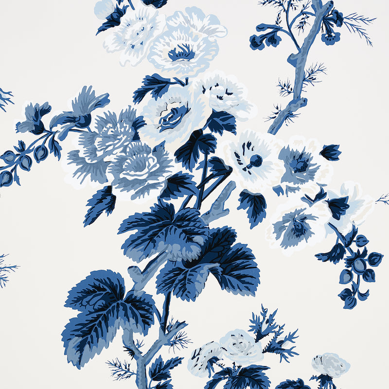 Pyne Hollyhock Indigo by Schumacher - a hand-screened floral chintz wallpaper in blue and white, shown in various interior settings.