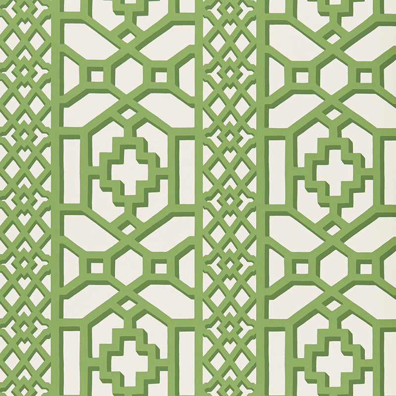 Zanzibar Trellis Jade geometric trellis wallpaper by Schumacher shown in a modern entryway with white paneling and green accents.