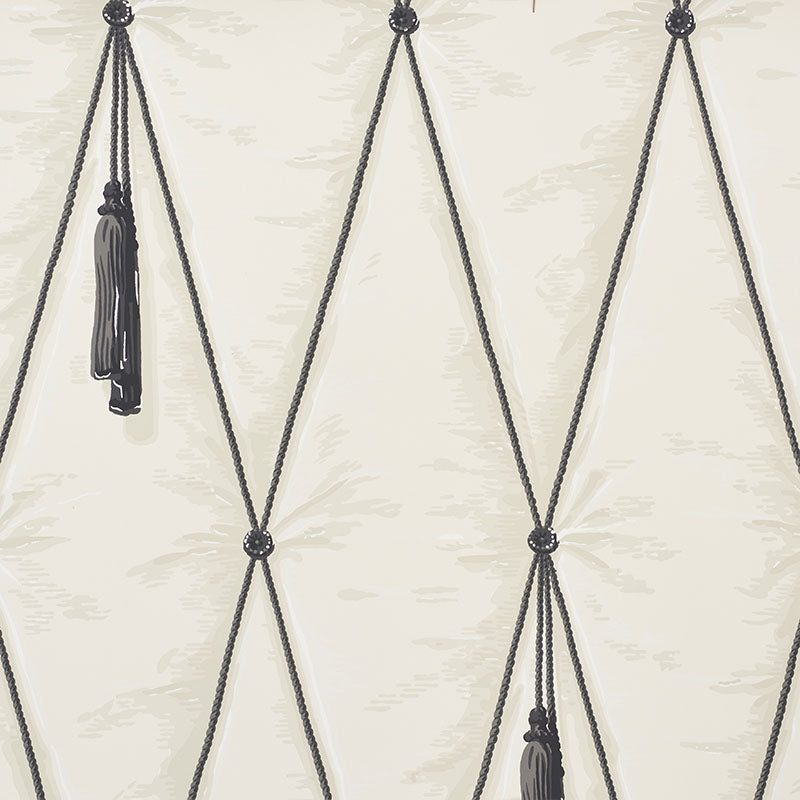 Bone colored trompe l'oeil wallpaper with diamond tufting and tassel design by Schumacher