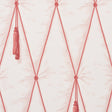 Blush pink diamond tufted trompe l'oeil wallpaper with hanging tassels by Schumacher, styled in a bedroom setting.