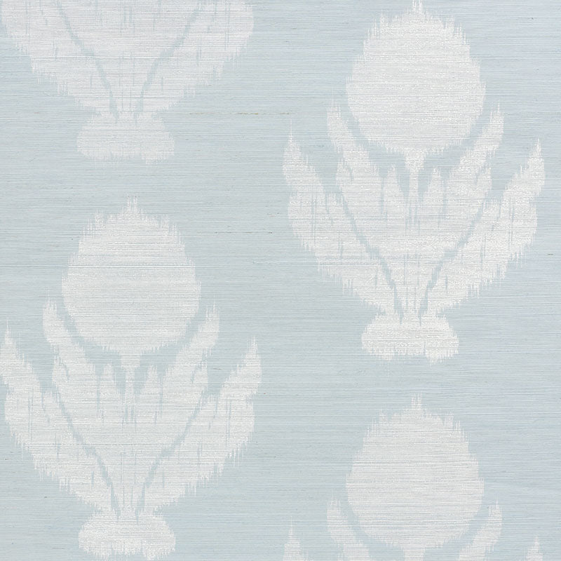 Agra Sisal wallpaper in Sky by Schumacher, featuring a soft-edged floral ikat pattern on a natural sisal ground, shown in a bathroom interior.