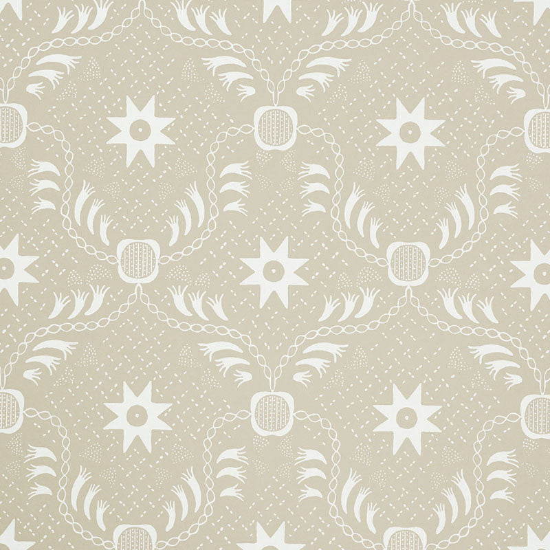 Lancaster Sand by Schumacher - geometric star and chain pattern wallpaper in beige and white, styled in a modern living room.
