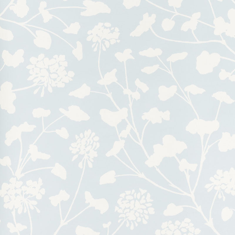 Pennick Sky painterly floral wallpaper by Schumacher in a crisp white silhouette on a soft blue background, styled in a modern interior.