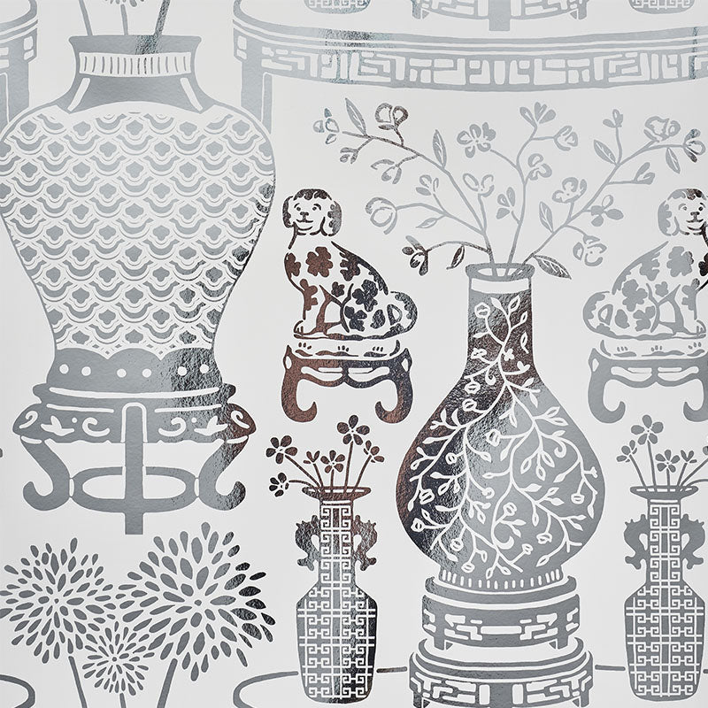 HELLENE MYLAR wallpaper features a preppy chinoiserie design with Ming vases and Staffordshire dogs in a mirrored silver pattern by Schumacher.