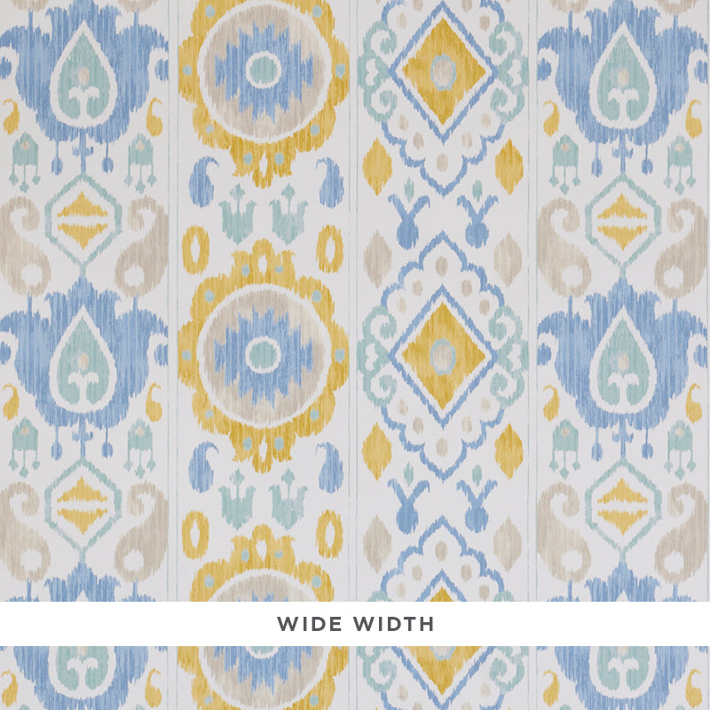 ELIZIA IKAT wallpaper in sky and ochre, a wide-width wallcovering with a delicate ikat pattern in blue, yellow, and beige tones.