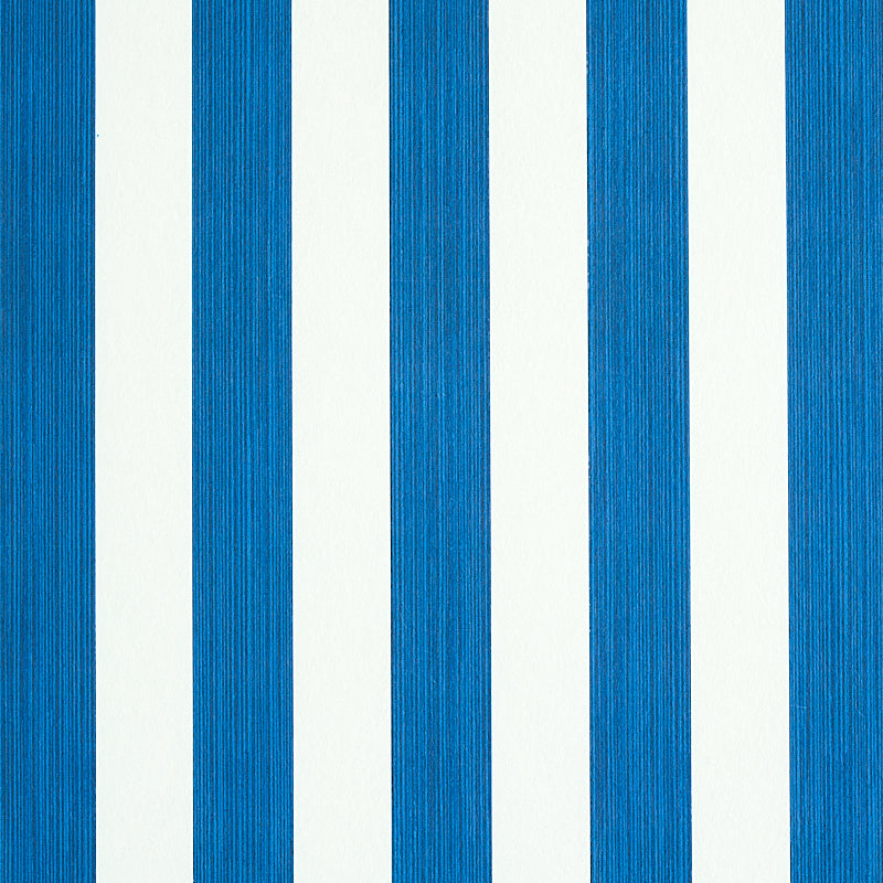 Edwin Stripe Medium navy blue and white striped wallpaper by Schumacher, shown in close-up and installed in a bedroom setting.