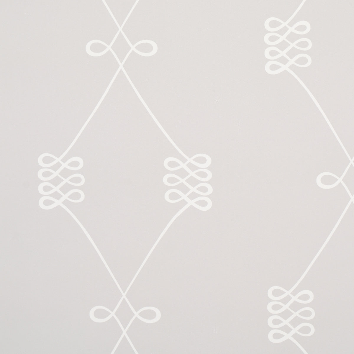 Nicolette wallpaper in white on grey, featuring a swirling trellis motif by Schumacher.