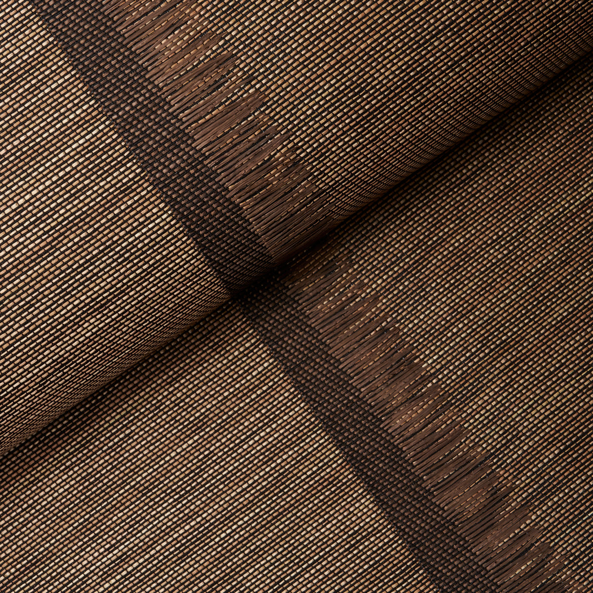 Axel Fringe Wallcovering in brown and copper, a large-scale vertical stripe wallpaper with fringe detail by Schumacher, shown in a styled bedroom.