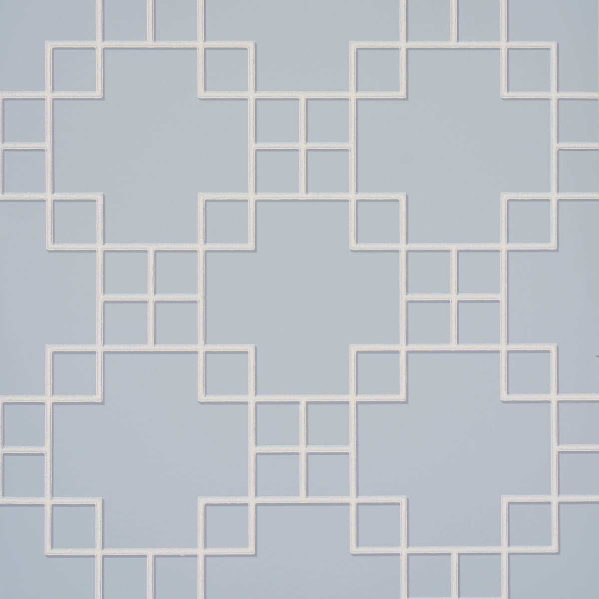 Georgette Trellis wallpaper in light blue with a geometric lattice pattern by Schumacher, shown in a styled bathroom interior.