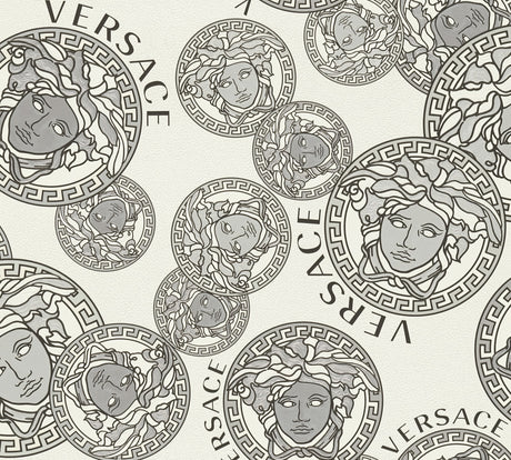Versace Dynasty wallpaper in Snowbound with grey Medusa medallions and Versace lettering on an off-white satin vinyl ground.