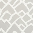 Zimba Fog by Schumacher - abstract hand-printed geometric wallpaper in soft grey and white, shown in a modern living room interior.