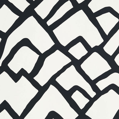 Zimba Ebony hand-printed wallpaper by Schumacher shown in a modern living room interior with bold black and white geometric pattern.