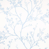Twiggy Sky wallpaper by Schumacher features delicate blue flowering branches silhouetted against a white background, creating a serene and airy look.
