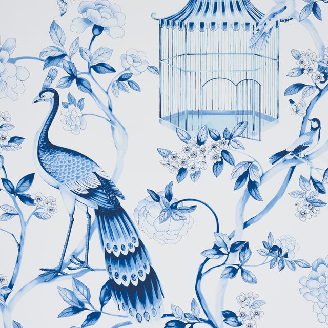 OISEAUX ET FLEURS wallpaper in Porcelain by Schumacher, featuring blue birds, birdcages, and flowers in a chinoiserie style.