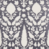 Chenonceau Charcoal wallpaper by Schumacher featuring white flora and fauna silhouettes on a charcoal background.