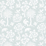 Palm Damask wallpaper in Sky by Schumacher, featuring a whimsical damask pattern with palm trees, birds, and animals in white on a pale blue background.