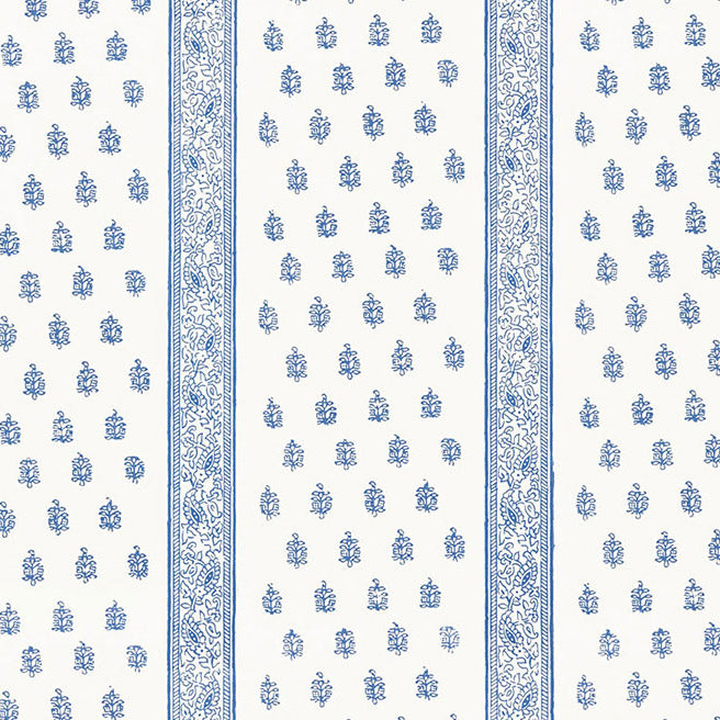 Katsura Stripe Delft wallpaper by Schumacher shown as a blue and white hand screen printed stripe and floral pattern in a bedroom interior.