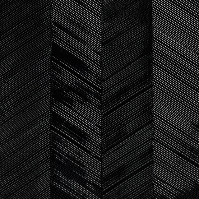 Chevron Texture Onyx wallcovering with raised diagonal stripes in a wide herringbone pattern and metallic luster by Schumacher.