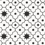 Taj Trellis Noir wallpaper by Schumacher shown in a modern interior with bold black and white geometric trellis pattern.