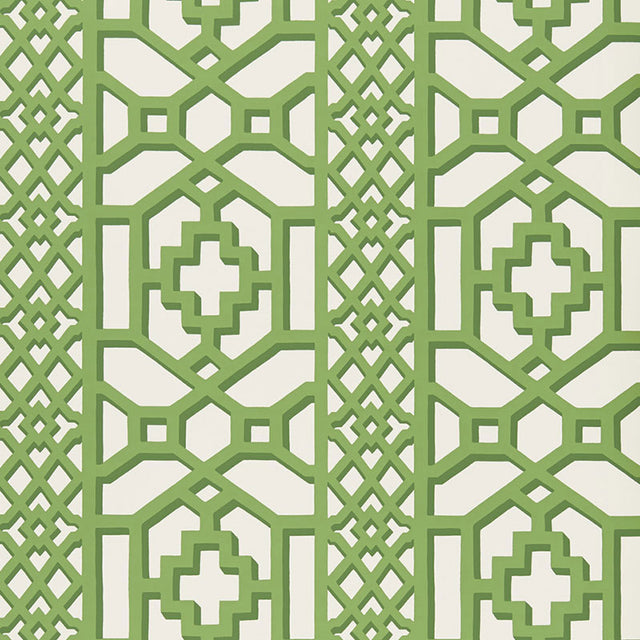 Zanzibar Trellis Jade geometric trellis wallpaper by Schumacher shown in a modern entryway with white paneling and green accents.