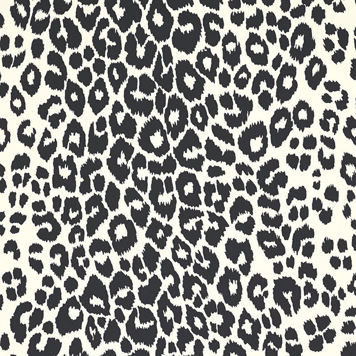 Iconic Leopard wallpaper in graphite by Schumacher, featuring a bold black and white animal print pattern on walls in various interior settings.