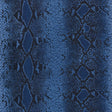 Snake Charmer Cobalt animal print wallpaper by Schumacher, shown in a close-up and installed in a modern interior.