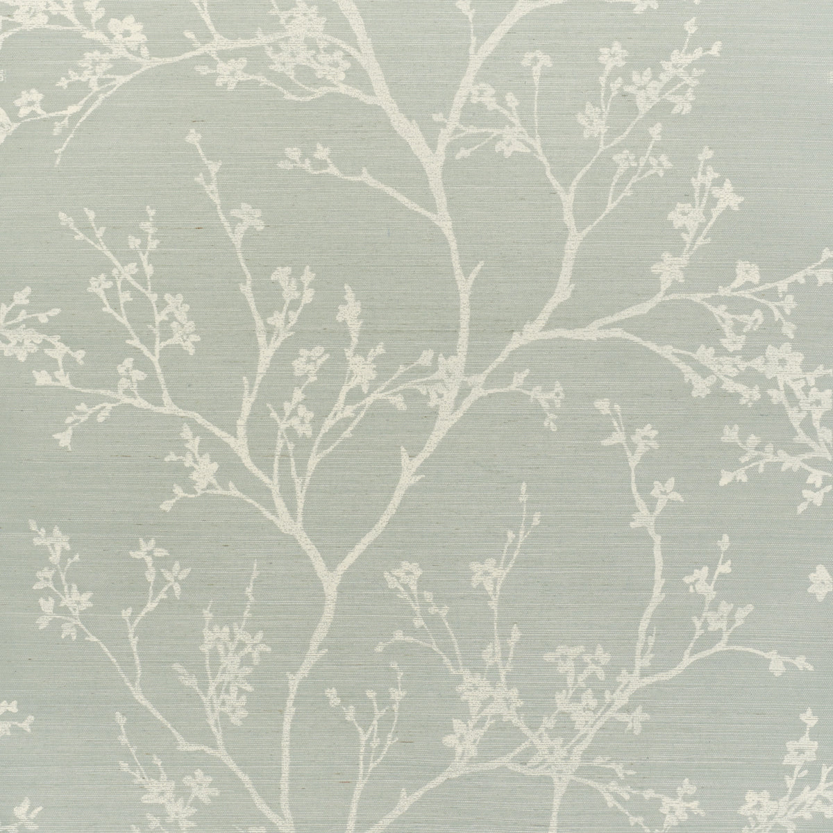 Twiggy Sisal wallpaper in Sky by Schumacher features delicate flowering branches silhouetted against a soft blue background, adding a serene, nature-inspired touch to interiors.