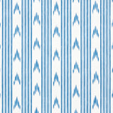 Santa Barbara Ikat Indigo wallpaper by Schumacher, featuring a blue and white ikat stripe pattern in a modern interior setting.