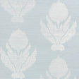 Agra Sisal wallpaper in Sky by Schumacher, featuring a soft-edged floral ikat pattern on a natural sisal ground, shown in a bathroom interior.