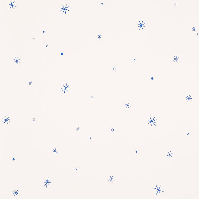 Calisto wallpaper in Ivory & Cobalt by Schumacher, featuring a playful scattered star motif in blue on an ivory background.