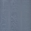 Moire Ocean wallcovering by Schumacher shown in a room setting with a dog on a chair, featuring a watery, irregular blue pattern.