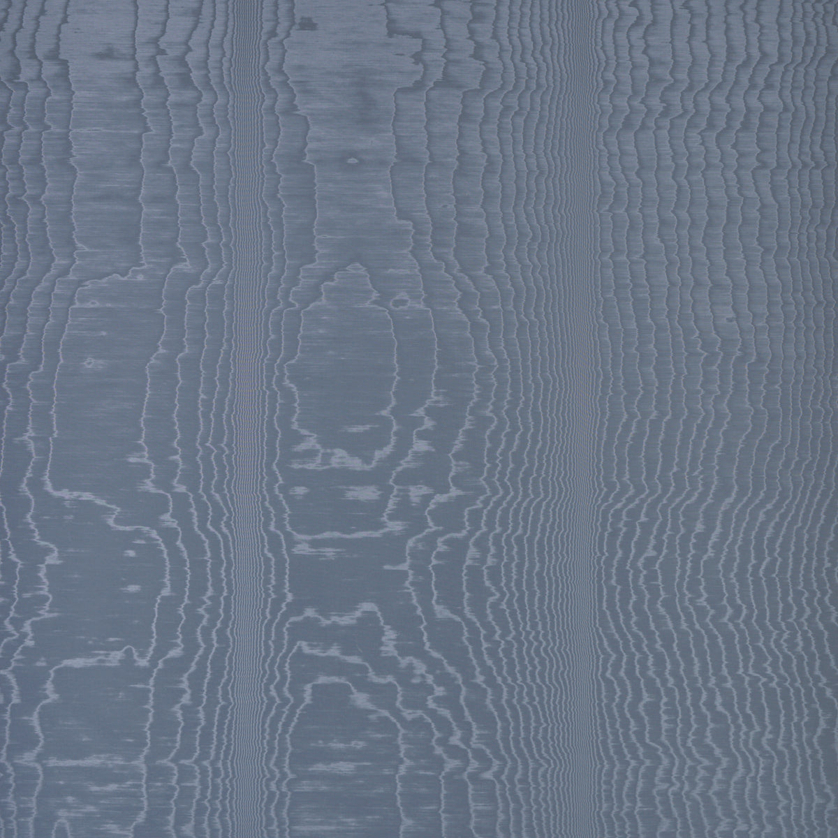 Moire Ocean wallcovering by Schumacher shown in a room setting with a dog on a chair, featuring a watery, irregular blue pattern.
