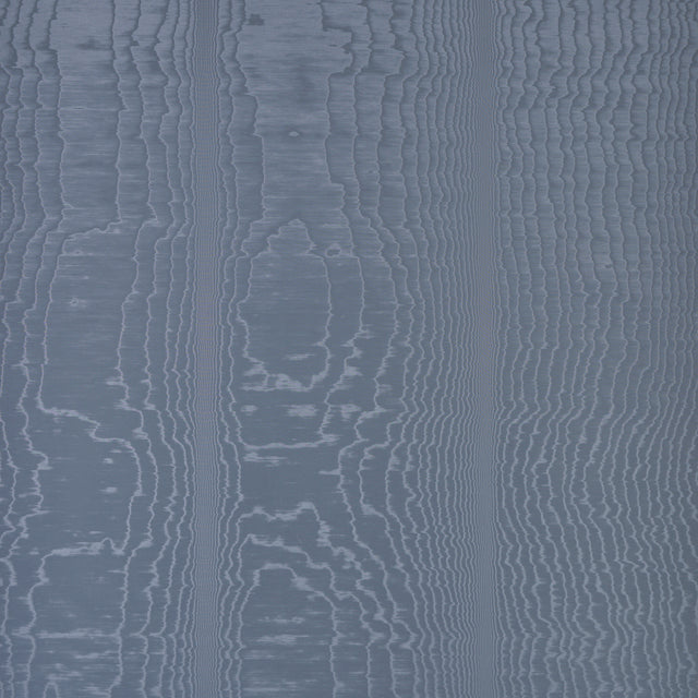 Moire Ocean wallcovering by Schumacher shown in a room setting with a dog on a chair, featuring a watery, irregular blue pattern.