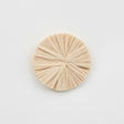 A set of natural raffia flower wall decor pieces arranged on a neutral wall, showcasing their textured, handcrafted appearance.