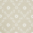 Lancaster Sand by Schumacher - geometric star and chain pattern wallpaper in beige and white, styled in a modern living room.