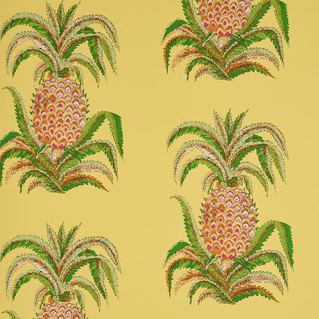 Yellow wallpaper with a repeating pineapple motif and green leaves, inspired by 18th-century Indian design, by Schumacher.