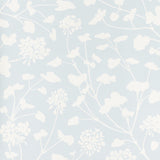 Pennick Sky painterly floral wallpaper by Schumacher in a crisp white silhouette on a soft blue background, styled in a modern interior.