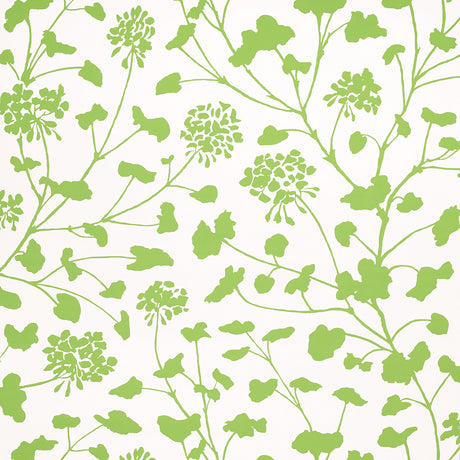 Pennick Leaf on Ivory wallpaper by Schumacher features a painterly green floral silhouette on an ivory background, shown in a bright, airy bathroom setting.