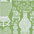 Green wallpaper with white Ming vases, Staffordshire dogs, and floral motifs in a mirrored repeat pattern.
