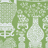 Green wallpaper with white Ming vases, Staffordshire dogs, and floral motifs in a mirrored repeat pattern.