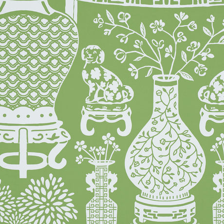 Green wallpaper with white Ming vases, Staffordshire dogs, and floral motifs in a mirrored repeat pattern.