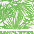 Sunlit Palm green palm leaf watercolor wallpaper by Schumacher shown in a bedroom interior and close-up detail.