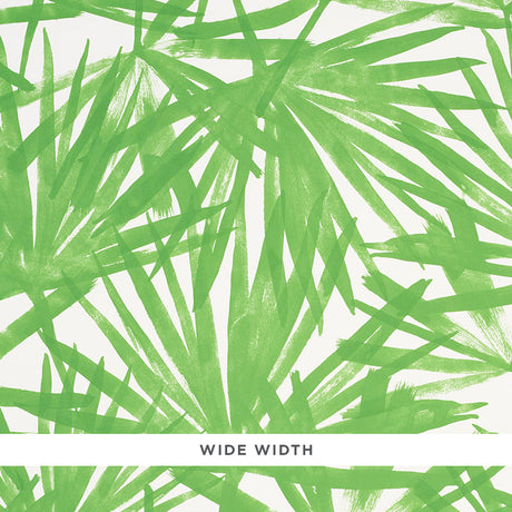 Sunlit Palm green palm leaf watercolor wallpaper by Schumacher shown in a bedroom interior and close-up detail.
