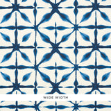 Andromeda blue shibori-inspired geometric wallpaper by Schumacher shown in close-up and installed in a kitchen interior.