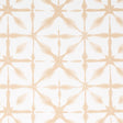 ANDROMEDA wallpaper in Sand by Schumacher, a shibori-inspired geometric pattern in soft beige tones, shown in a modern interior setting.